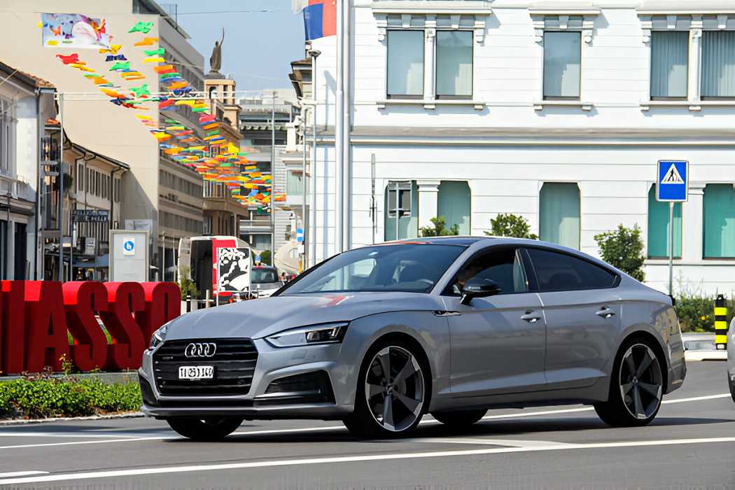 "A sleek silver Audi A2 parked outdoors, showcasing its iconic rounded design and lightweight aluminum body."