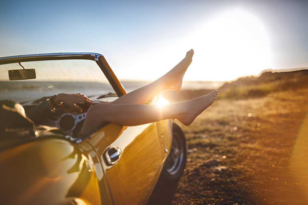 Bright yellow sports car parked on a scenic road, showcasing its sleek design and vibrant color.